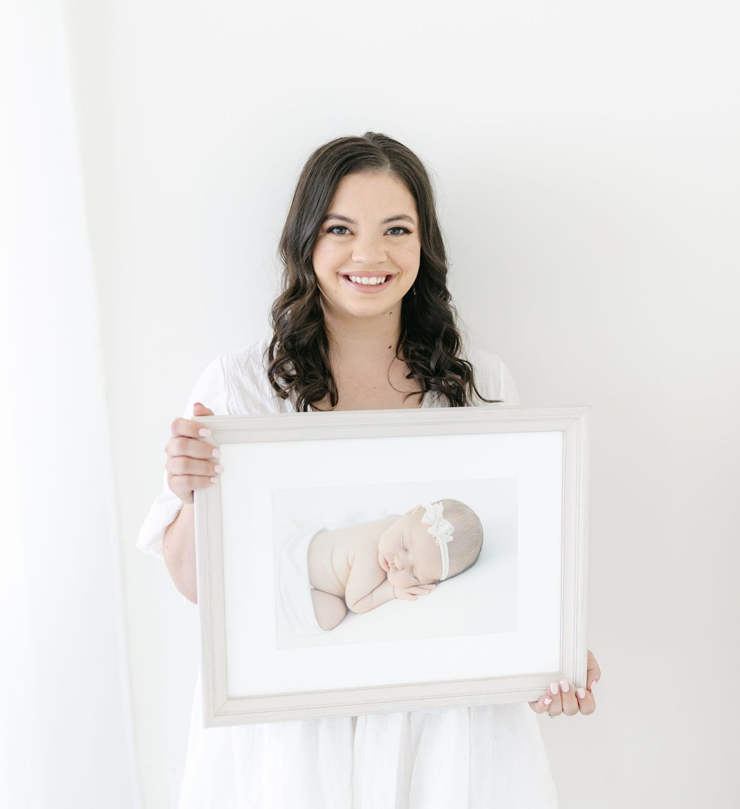 Woman photographer holding a picture of a newborn